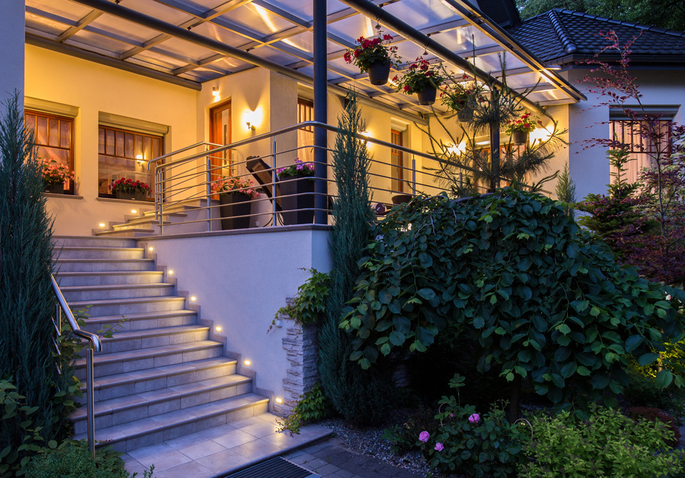 Beautiful house with garden in the evening with lamps on