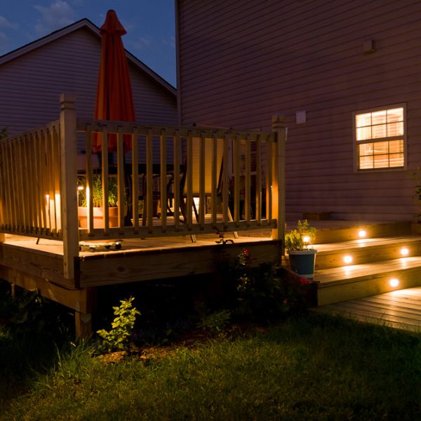 Wooden deck and patio of family home at night.